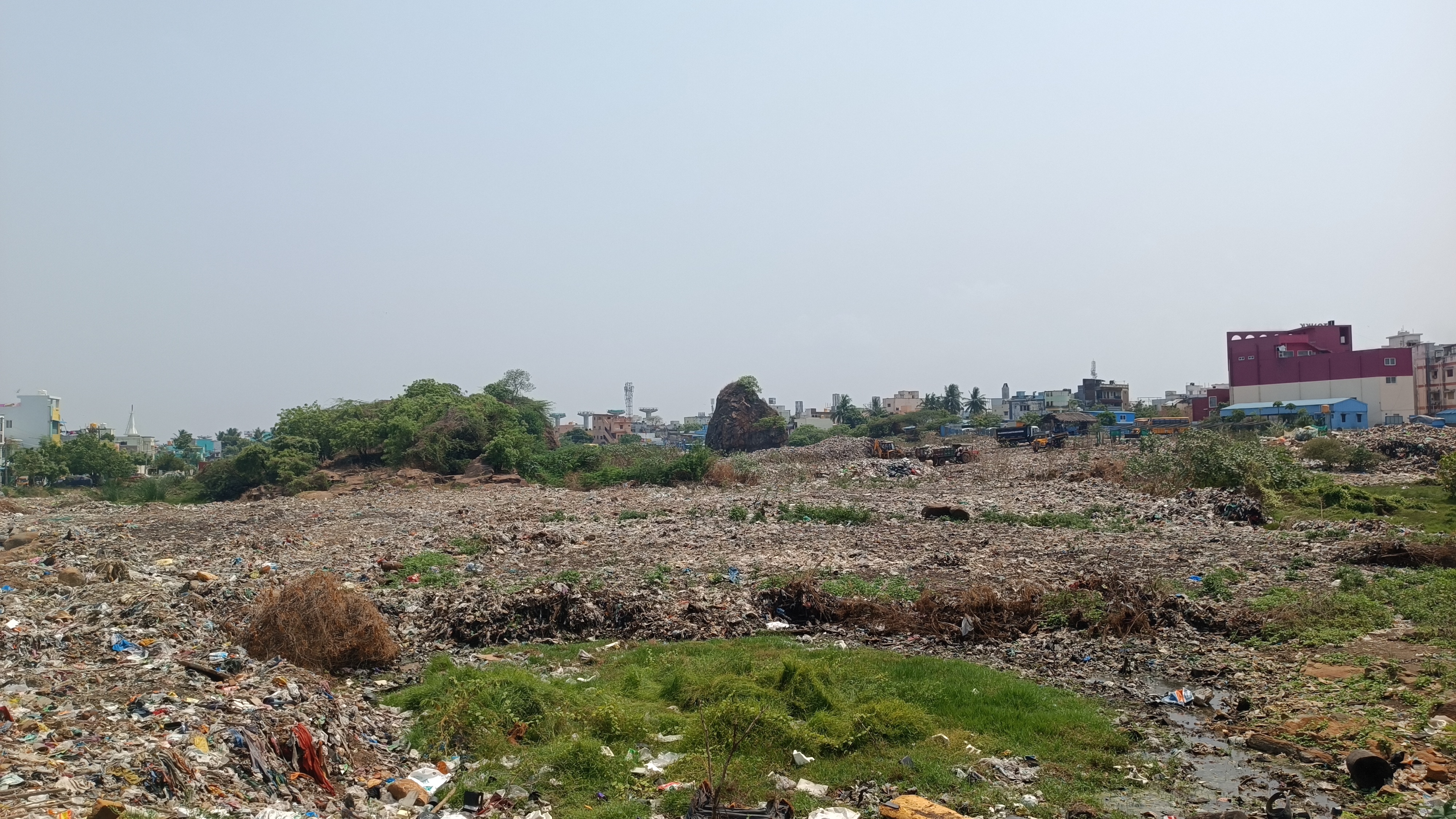 Polluted waterbody, waste, and rocky embankment